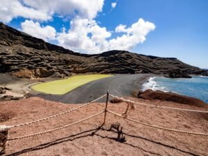 Green lagoon and black volcanic cliffs on the Lanzarote coast