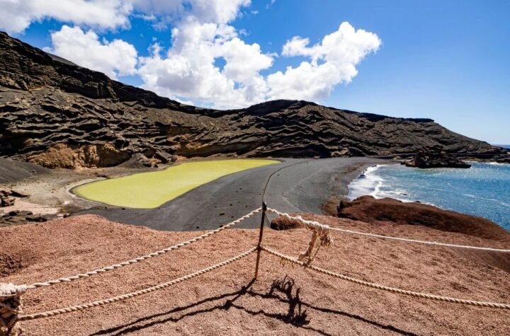 Green lagoon and black volcanic cliffs on the Lanzarote coast